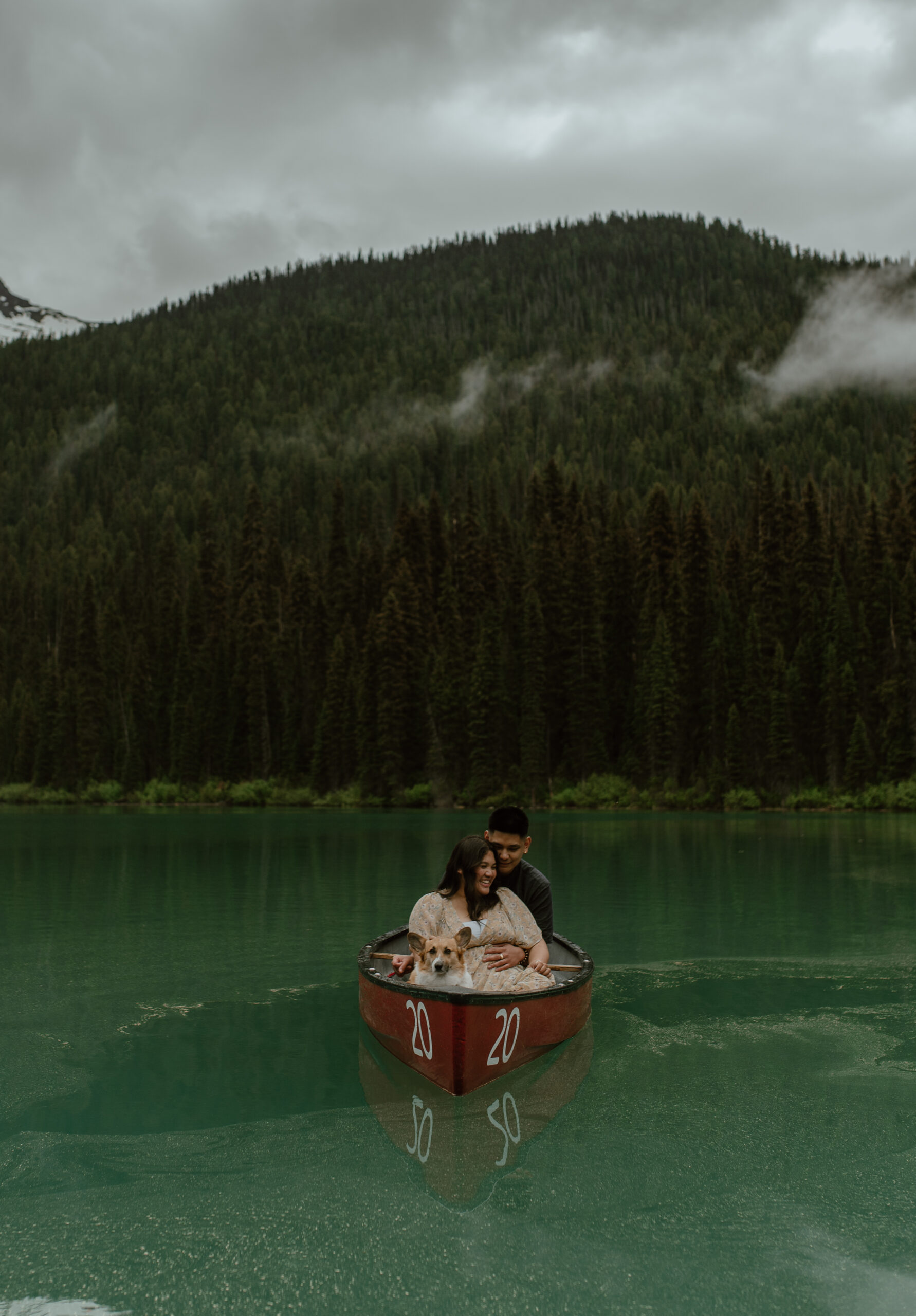 dramatic landscape shot of couple in canoe on glacier lake in Canada
