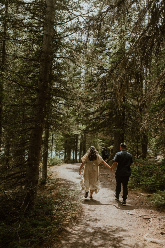 couple walking through forest in Banff National Park, Canada
