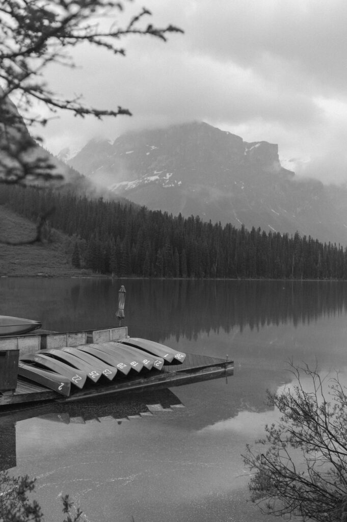 black and white photo of canoe dock on mountain lake in Canada