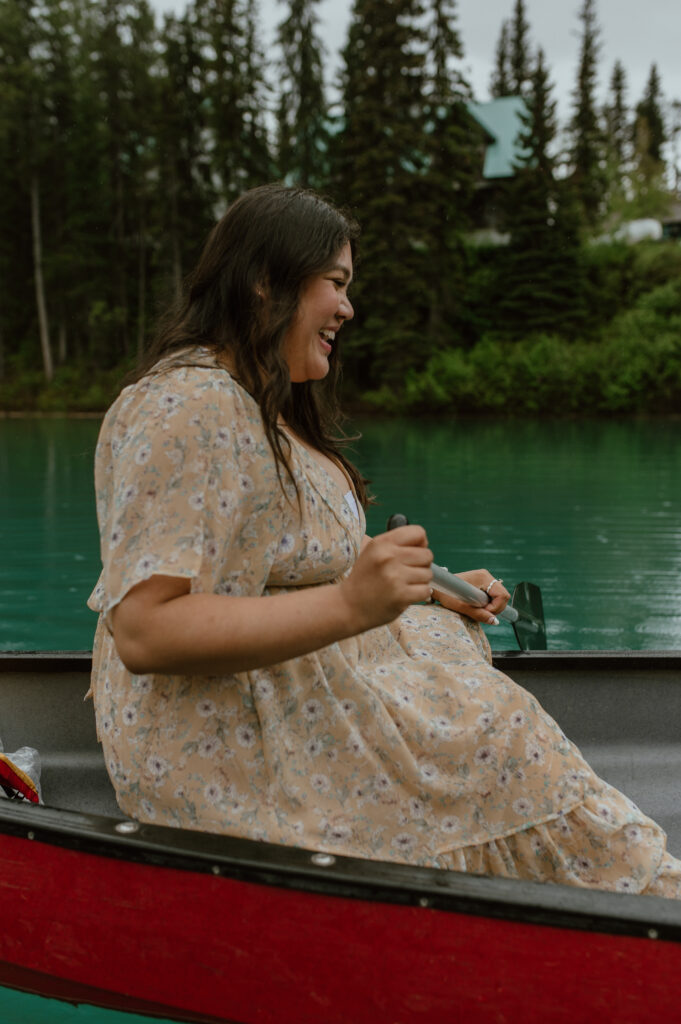 girl laughing in canoe during engagement session in Banff, Alberta