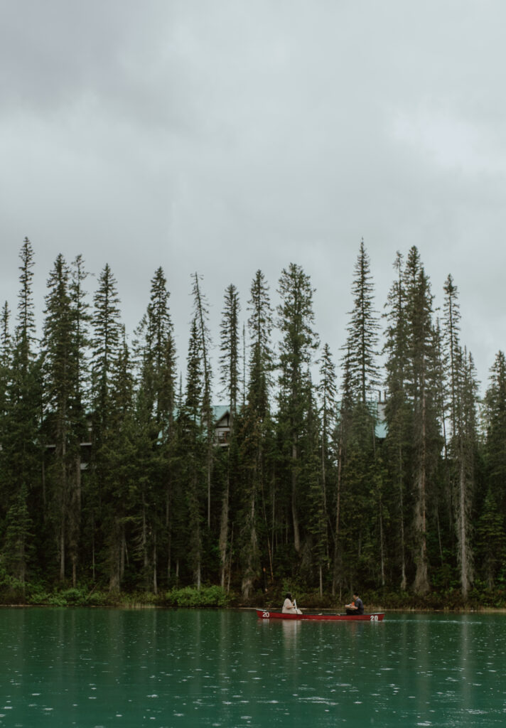 couple enjoying rainy canoe ride on Emerald Lake, British Columbia, Canada
