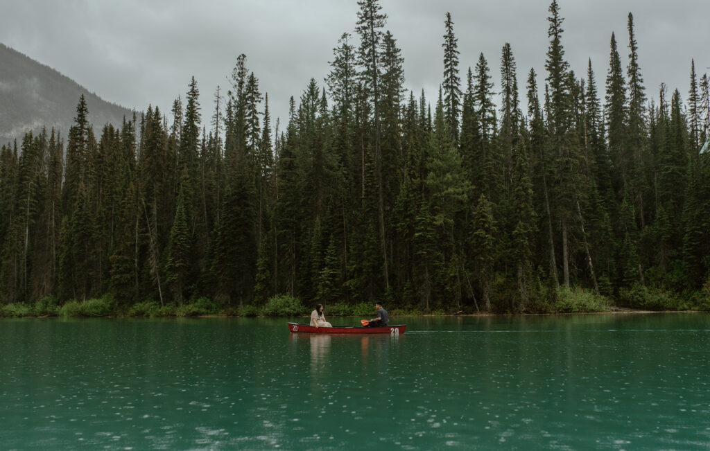 romantic couple canoeing in the rain on a mountain lake in Banff, Canada