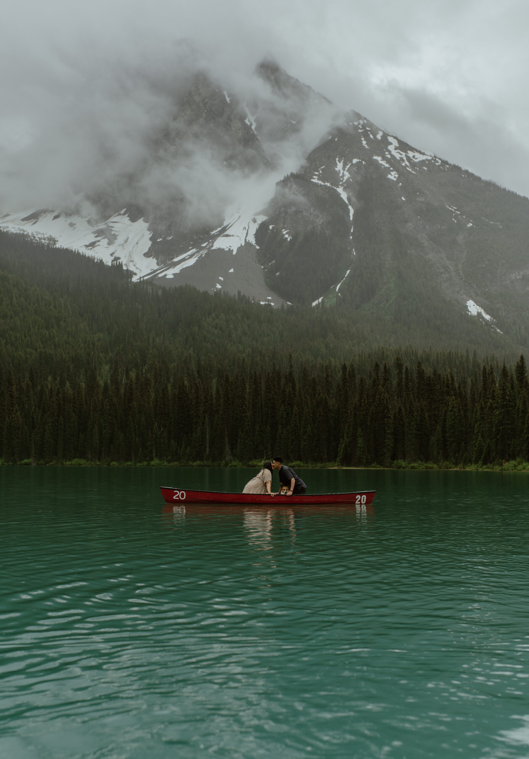 couple canoeing in the rain in the mountains of Canada