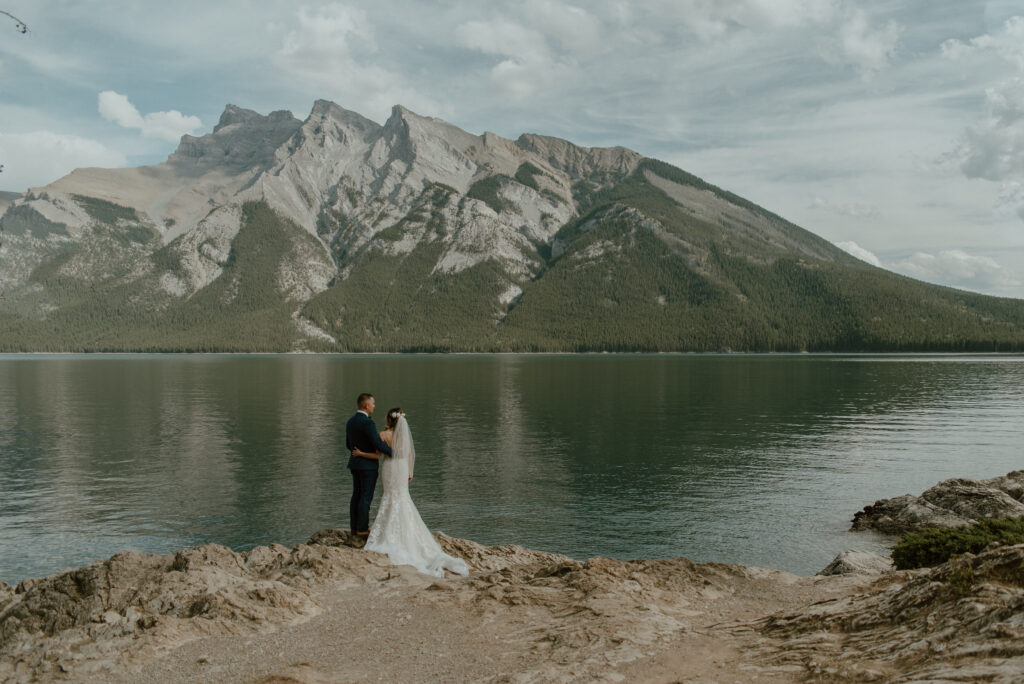 wedding couple in front of Lake Minnewanka in Banff, Alberta