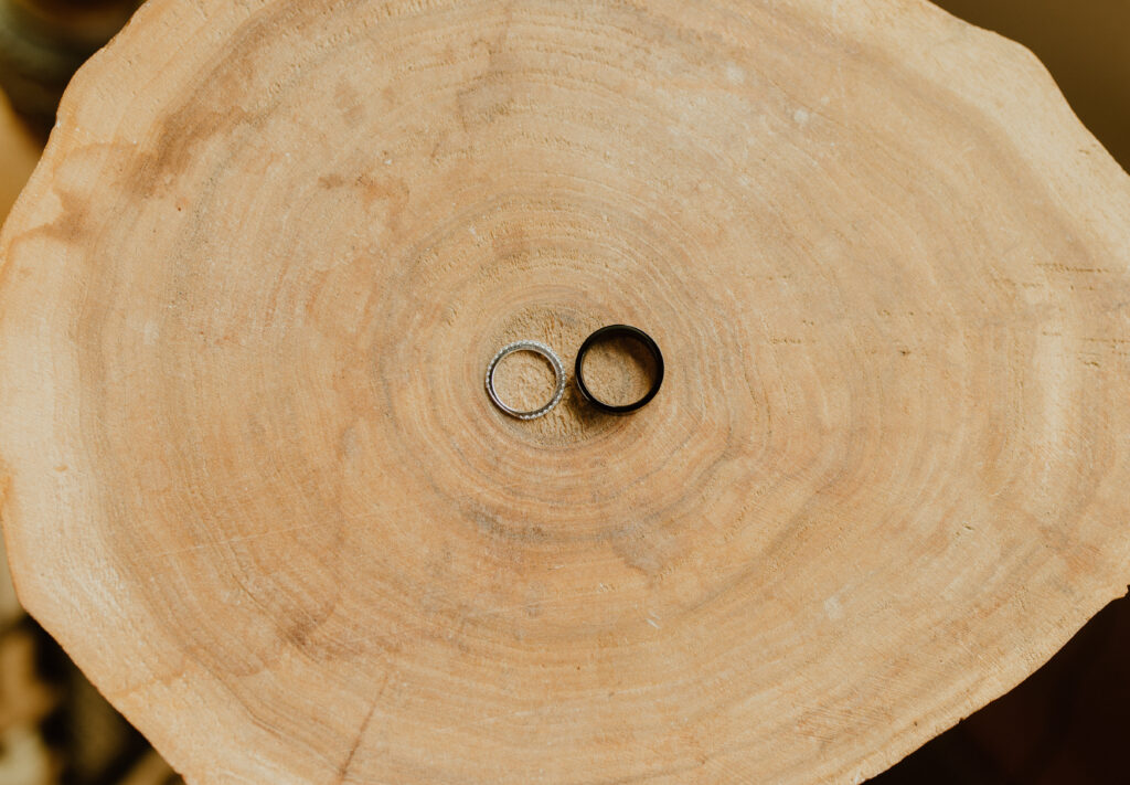 detail shot of wedding rings on wood before wedding ceremony in Alberta, Canada
