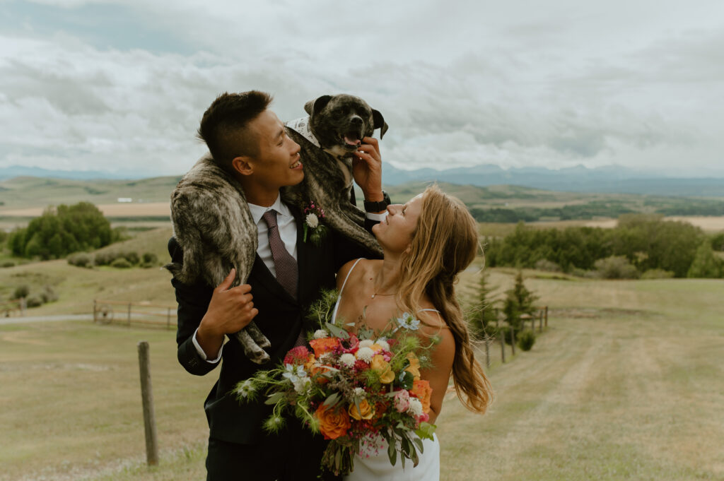 wedding couple posing with their dog before their ceremony in Alberta, Canada