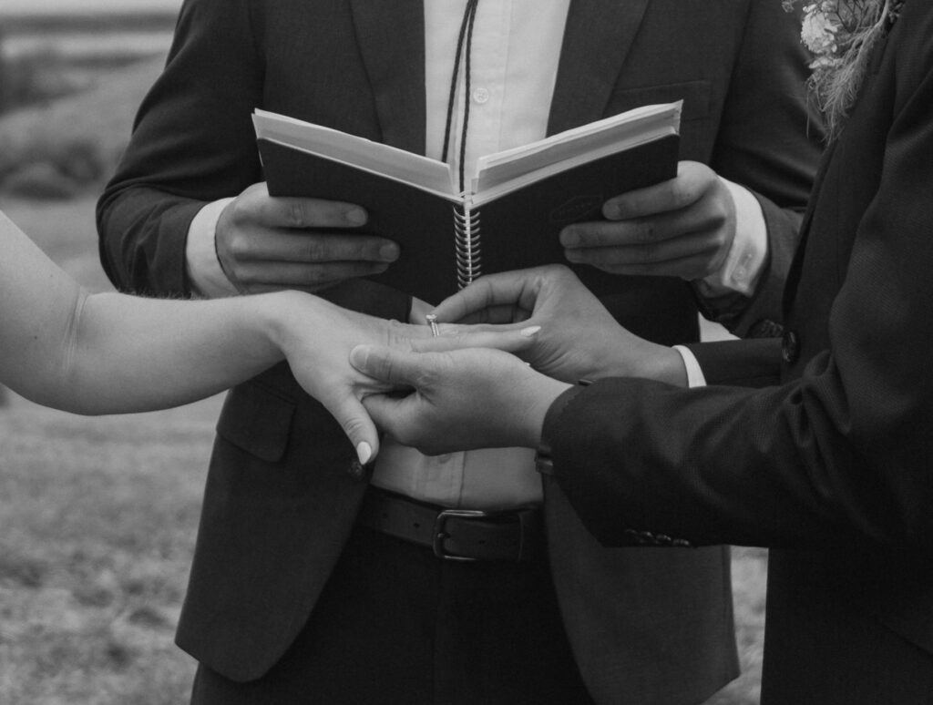 black and white photo of exchanging of rings during a foothills wedding in southern Alberta