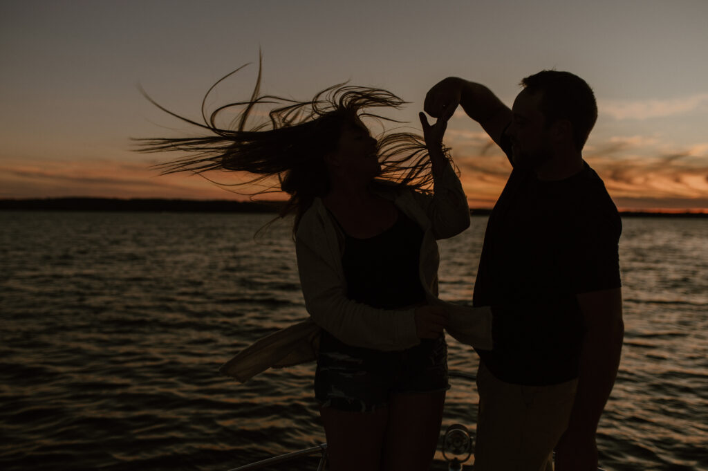 sunset silhouette couple dancing on a boat during an engagement session in Muskoka, Ontario