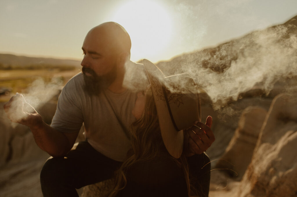 couple sharing a smoke together during a honeymoon session in Drumheller, Alberta