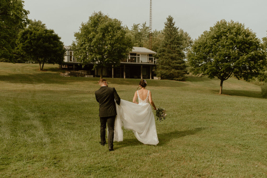 bride and groom walking towards house in southern ontario