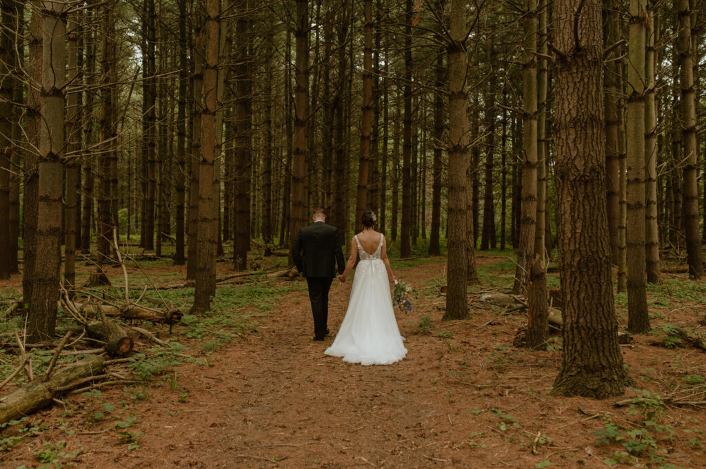wedding couple walking down makeshift aisle in a forest in southern ontario