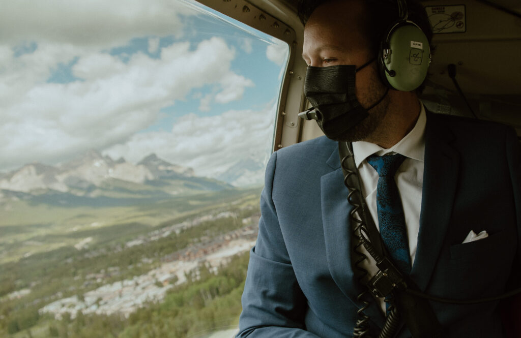 groom looking down at Canmore, Canada while on route to her mountain elopement