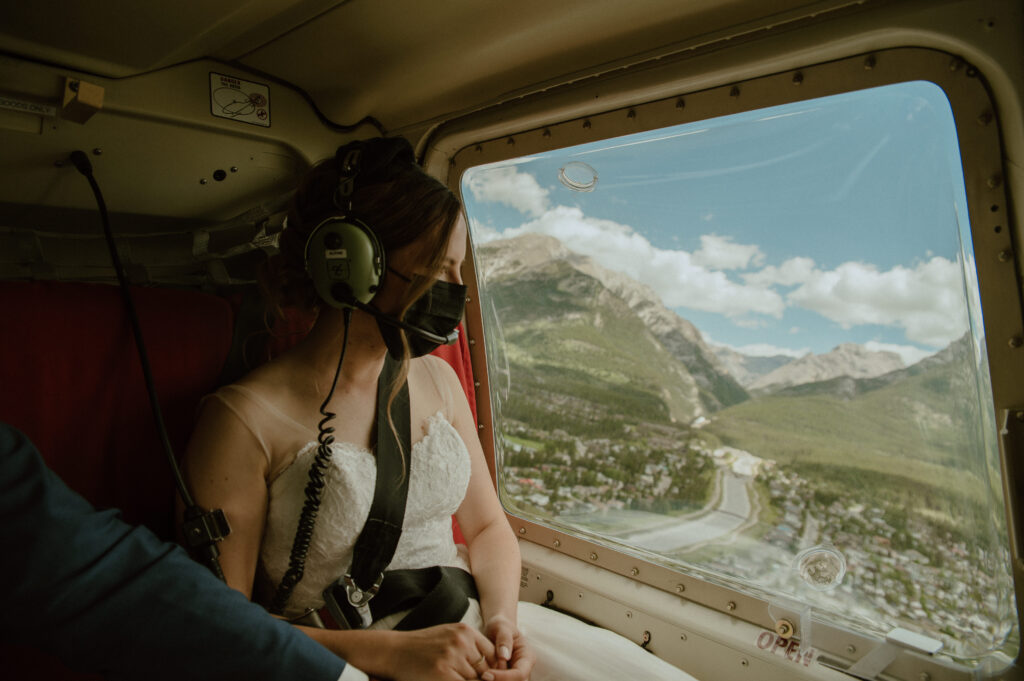 bride looking down at Canmore, Canada while on route to her mountain elopement