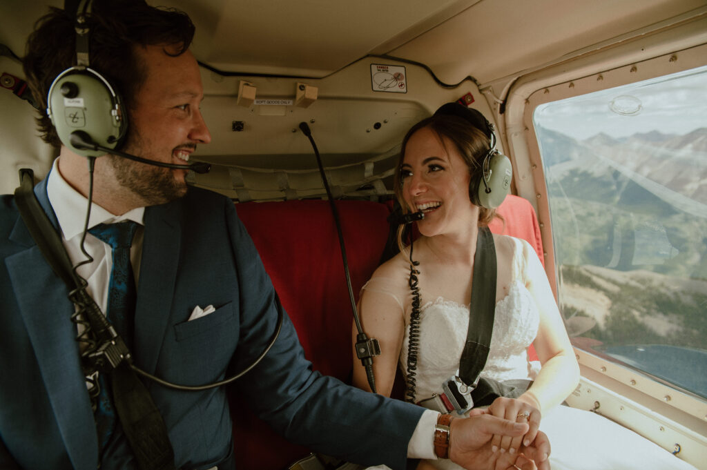 couple smiling at each other in a helicopter before they elope in the Canadian Rockies